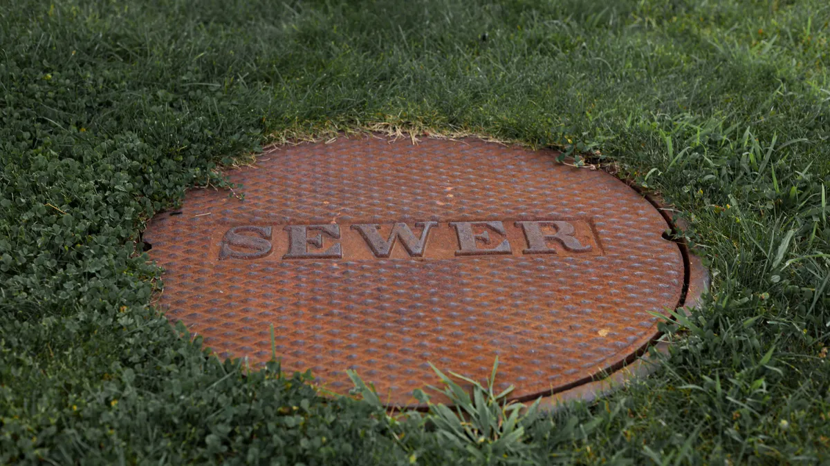 Sewer manhole cover in grass